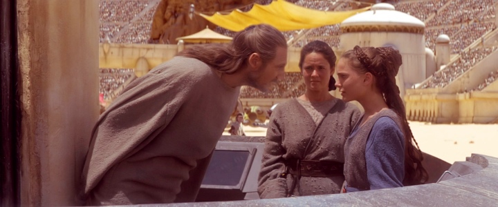 Qui-Gon leans down to tell Padmé to get over it while Shmi looks on with some dismay
